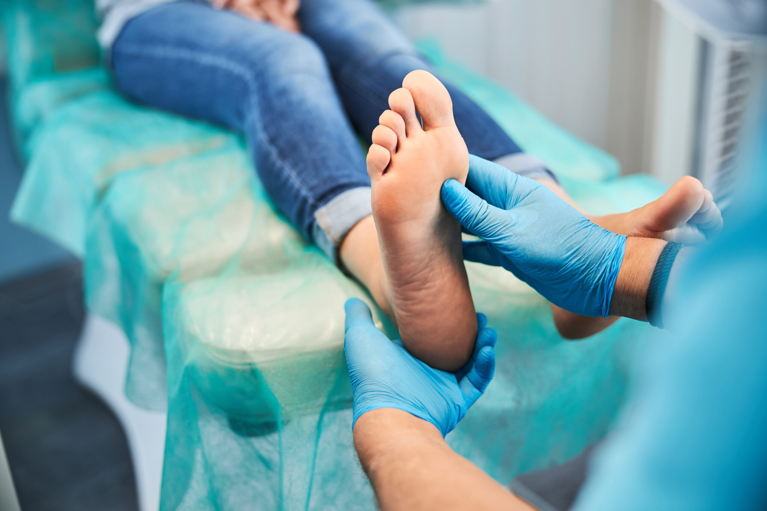Close up portrait of female clean feet in doctor hand while patient sitting on the medical chair in beauty clinic